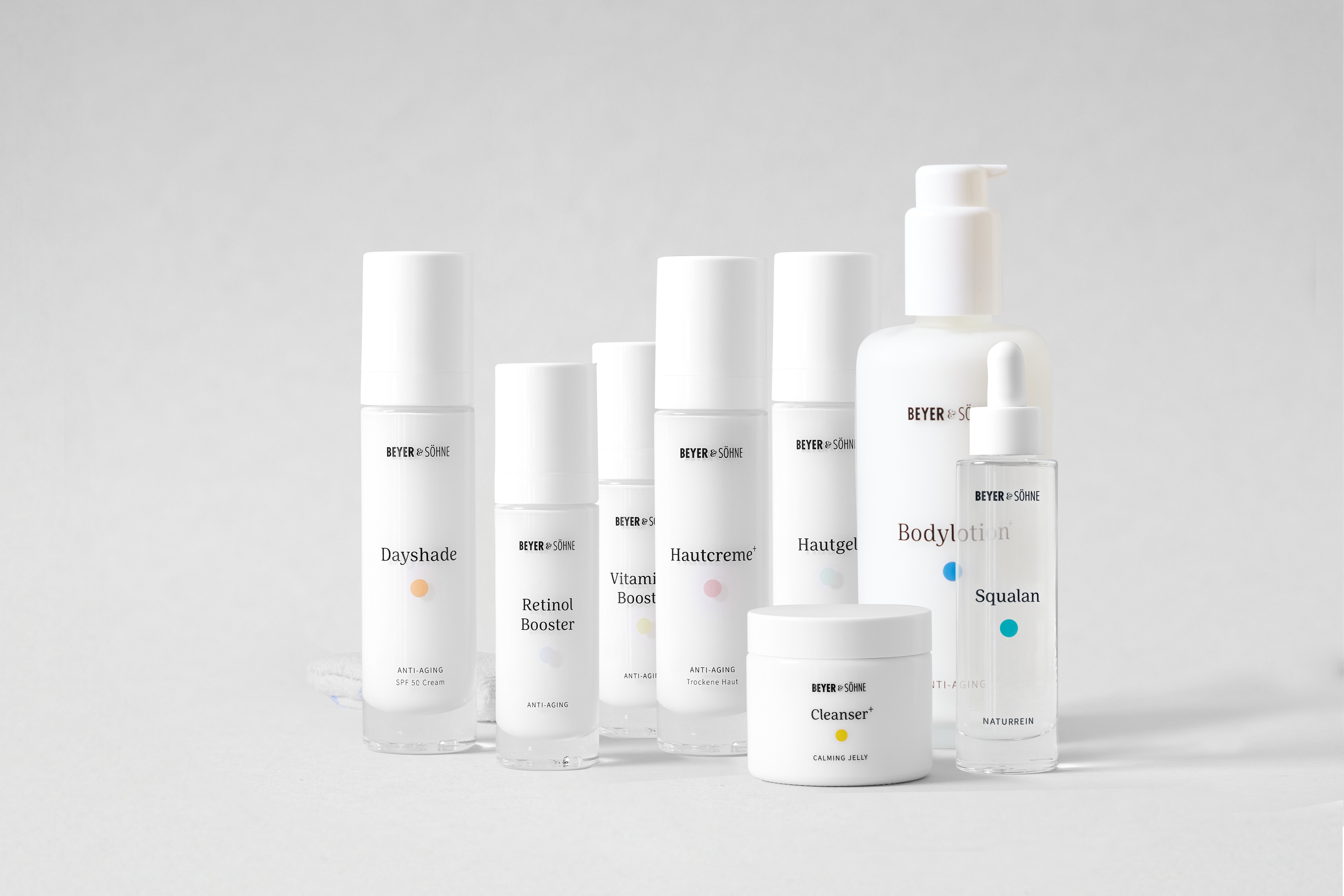 Produktlinie von Beyer & Söhne: Anti-Aging-Pflegeprodukte in minimalistischem Design. Abgebildet sind die Dayshade SPF 50, Retinol Booster, Vitamin C Booster, Hautcreme+ für trockene Haut, Hautgel, Cleanser+, Bodylotion+ und Squalan. Alle Produkte sind dermatologisch getestet, frei von Duftstoffen und speziell für empfindliche Haut geeignet. Perfekt für eine effektive und nachhaltige Pflegeroutine.