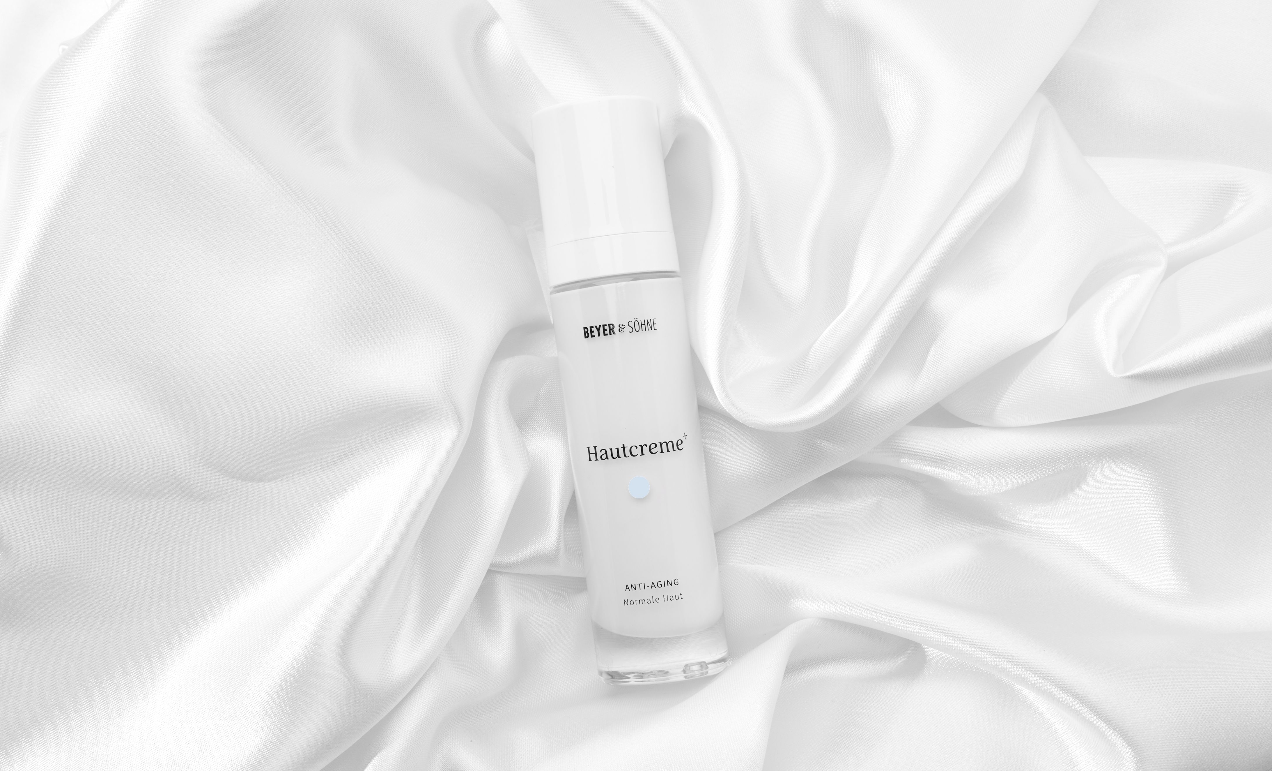 Hautcreme+ von Beyer & Söhne: parfumfreie Anti-Aging Gesichtscreme im Airless-Spender, auf weißer Seide in heller, minimalistischer Farbwelt