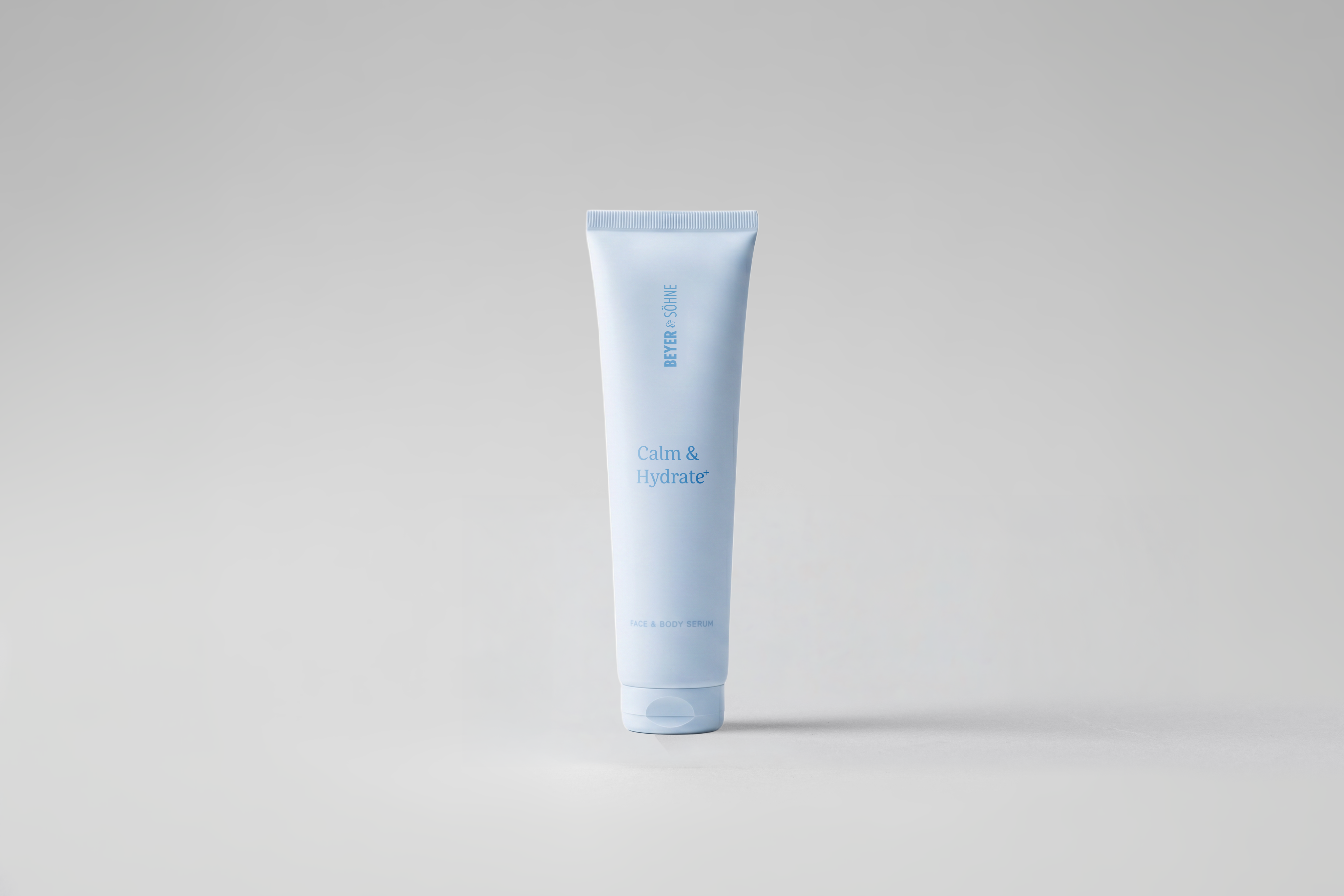 Calm & Hydrate+ in hellblauer Tube vor neutral grauem Hintergrund. Die reduzierte Darstellung unterstreicht den beruhigenden und feuchtigkeitsspendenden Charakter des Produkts.