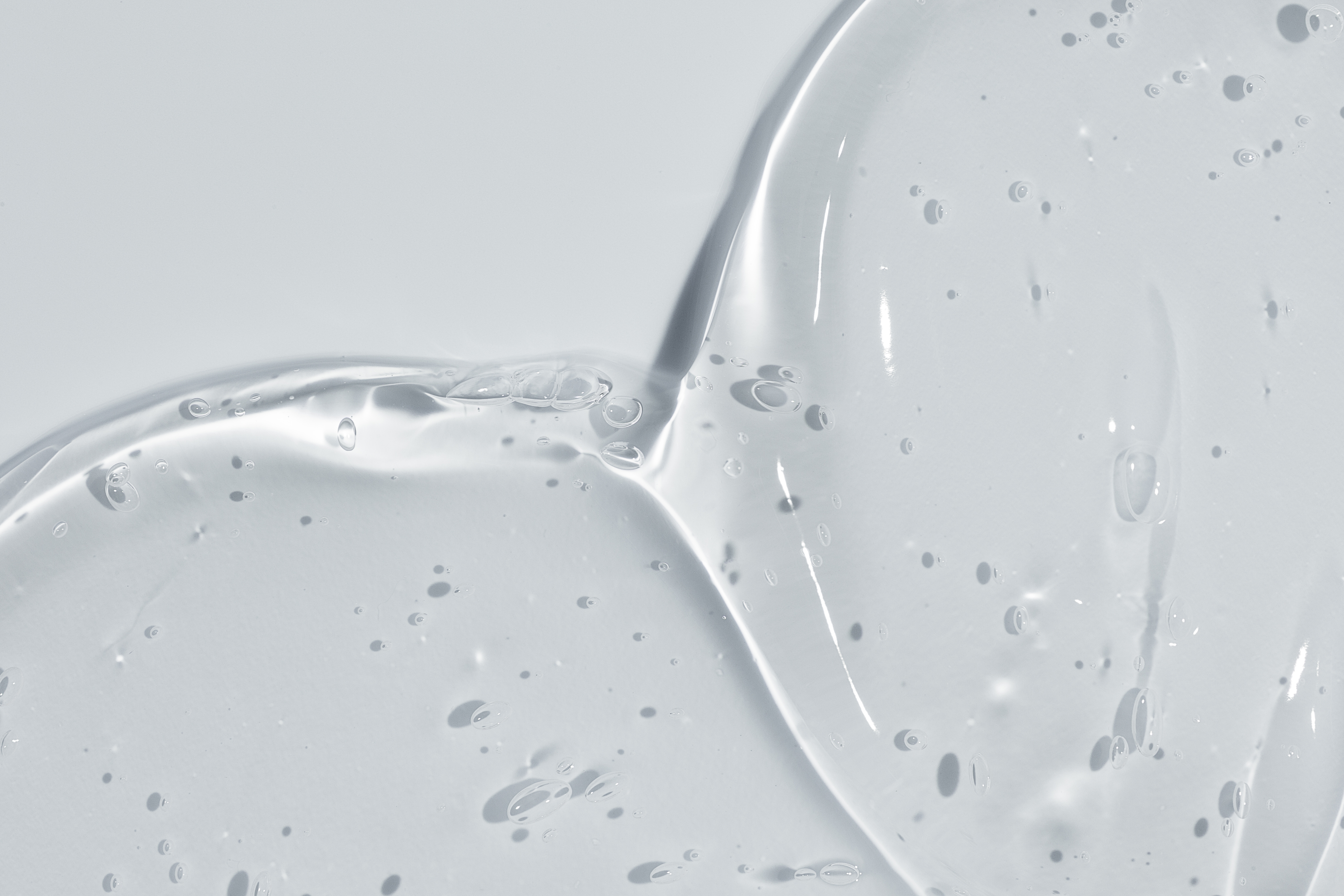 Nahaufnahme einer geligen, klaren Textur auf hellgrauem Hintergrund