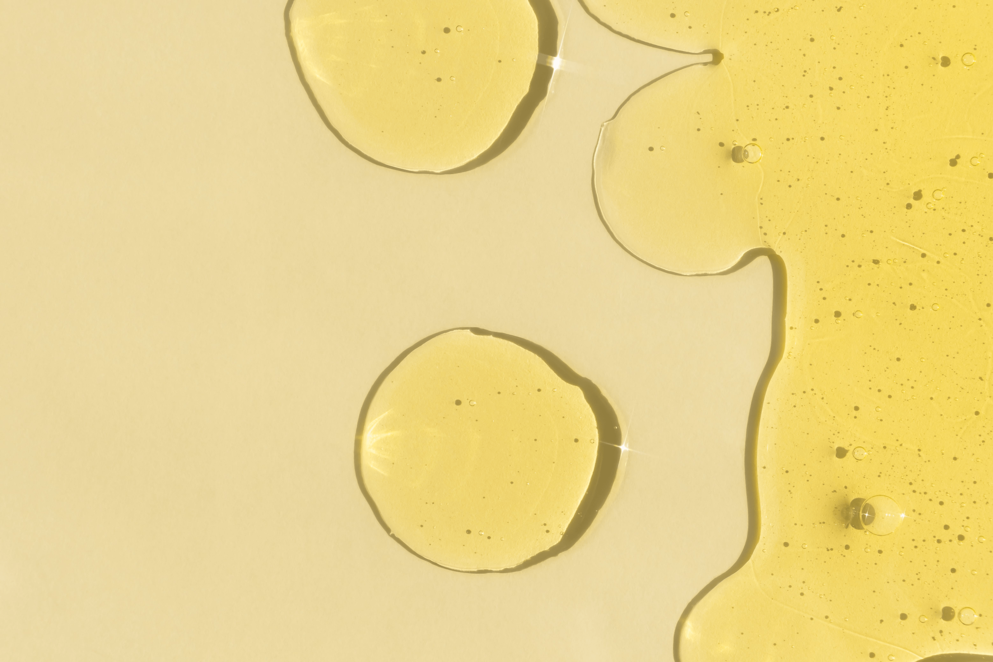 Skincare Inhaltsstoff Glucosylrutin, eine gelbe Flüssigkeit, vor gelbem Hintergrund.