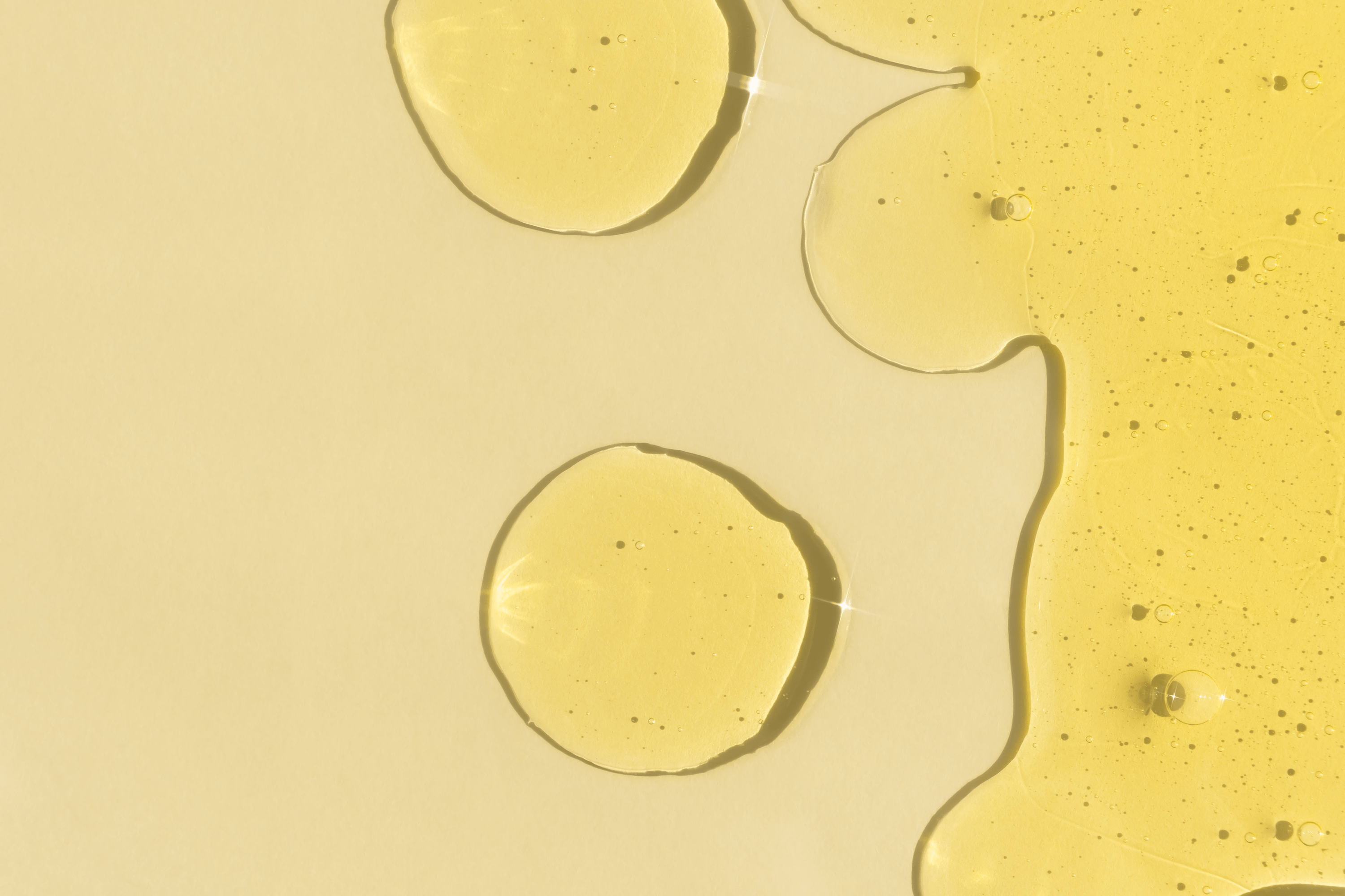 Skincare Inhaltsstoff Glucosylrutin, eine gelbe Flüssigkeit, vor gelbem Hintergrund. 