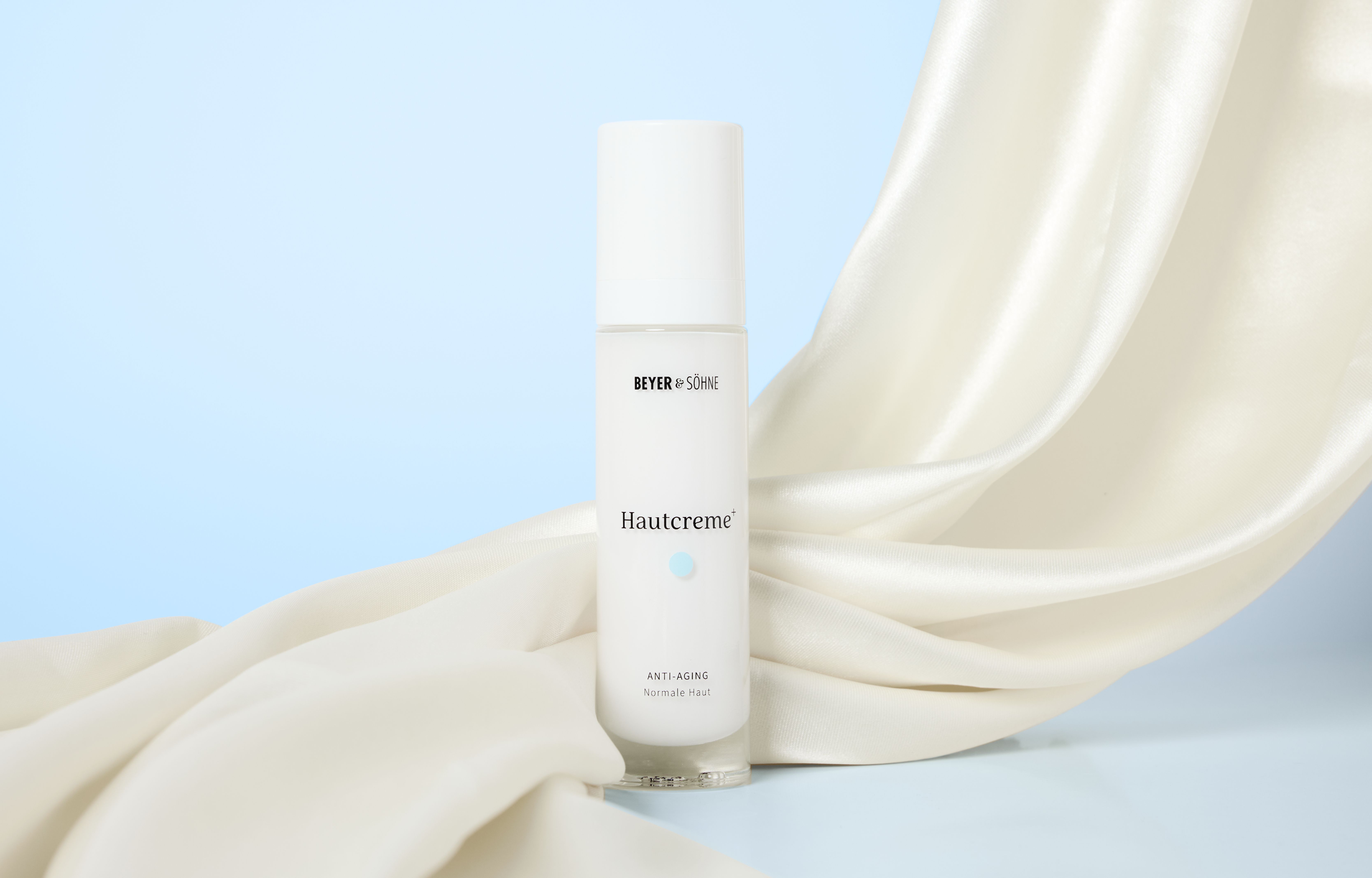 Hautcreme+ Anti-Aging Gesichtscreme von Beyer & Söhne für empfindliche Haut, im Airless-Spender auf weißer Seide, helle minimalistische Farbwelt