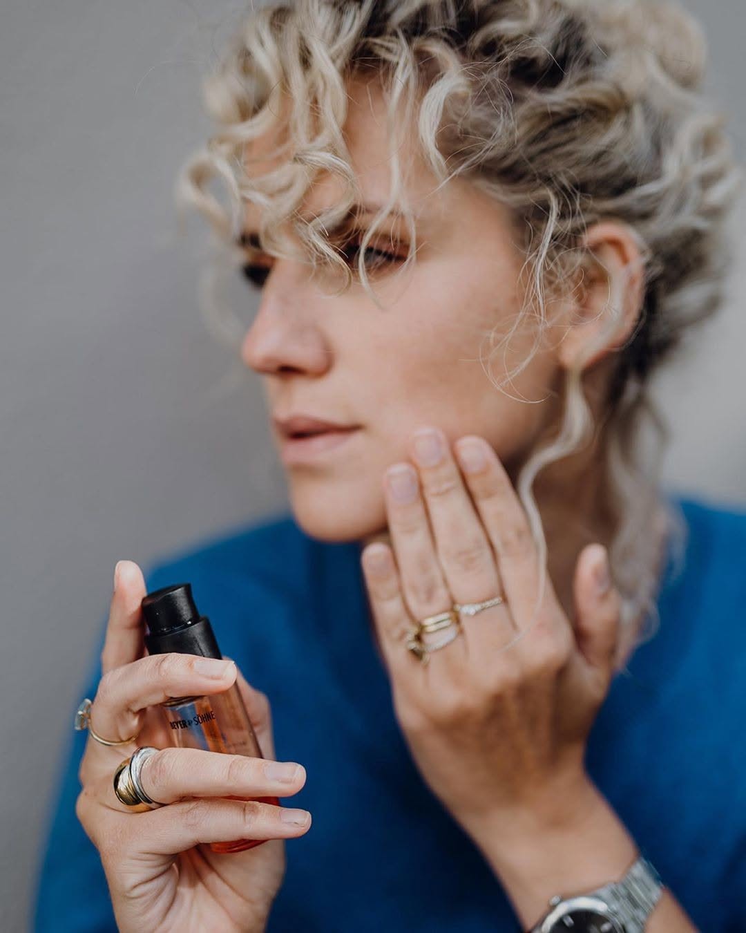 Frau mit rotem Sonenschutz-Öl Dayshade Fluid in der Hand