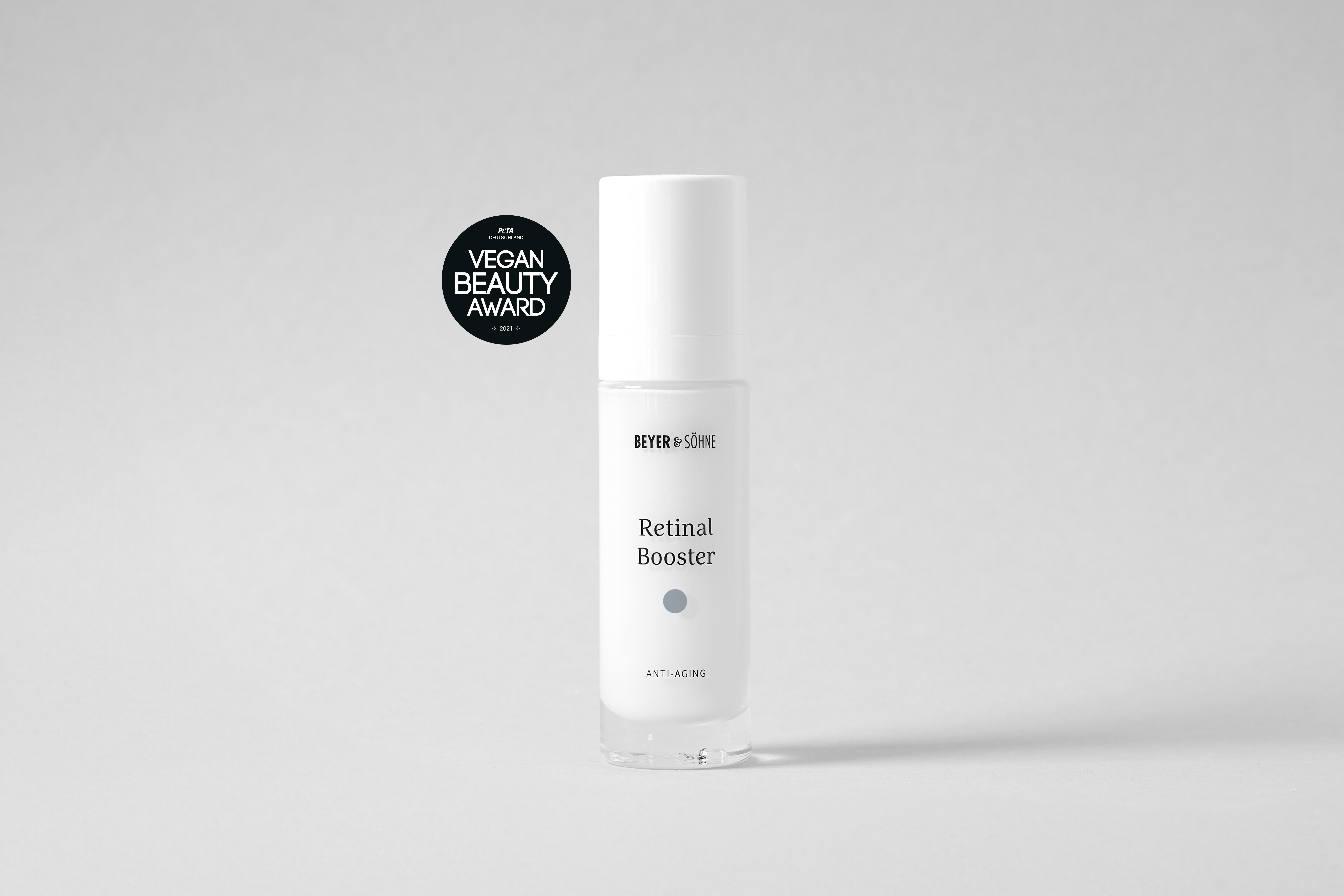 Produktfoto des Beyer & Söhne Retinal Boosters in schlichtem, edlen weißem Pumpspender auf neutral grauem Hintergrund mit dem „PETA Vegan Award Beauty 2026“ Siegel.