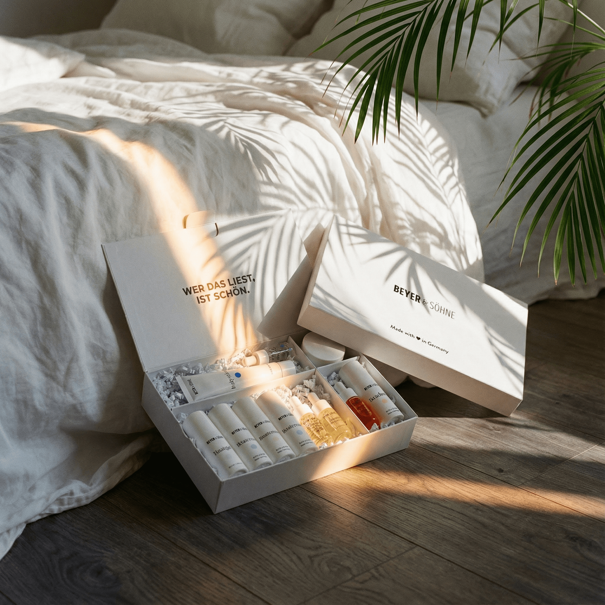 Beyer & Söhne Testerset mit Hautpflegeprodukten in hochwertiger Geschenkbox auf Bett, natürliche Lichtstimmung, ideal zum Kennenlernen der Pflegeroutine – Made in Germany.