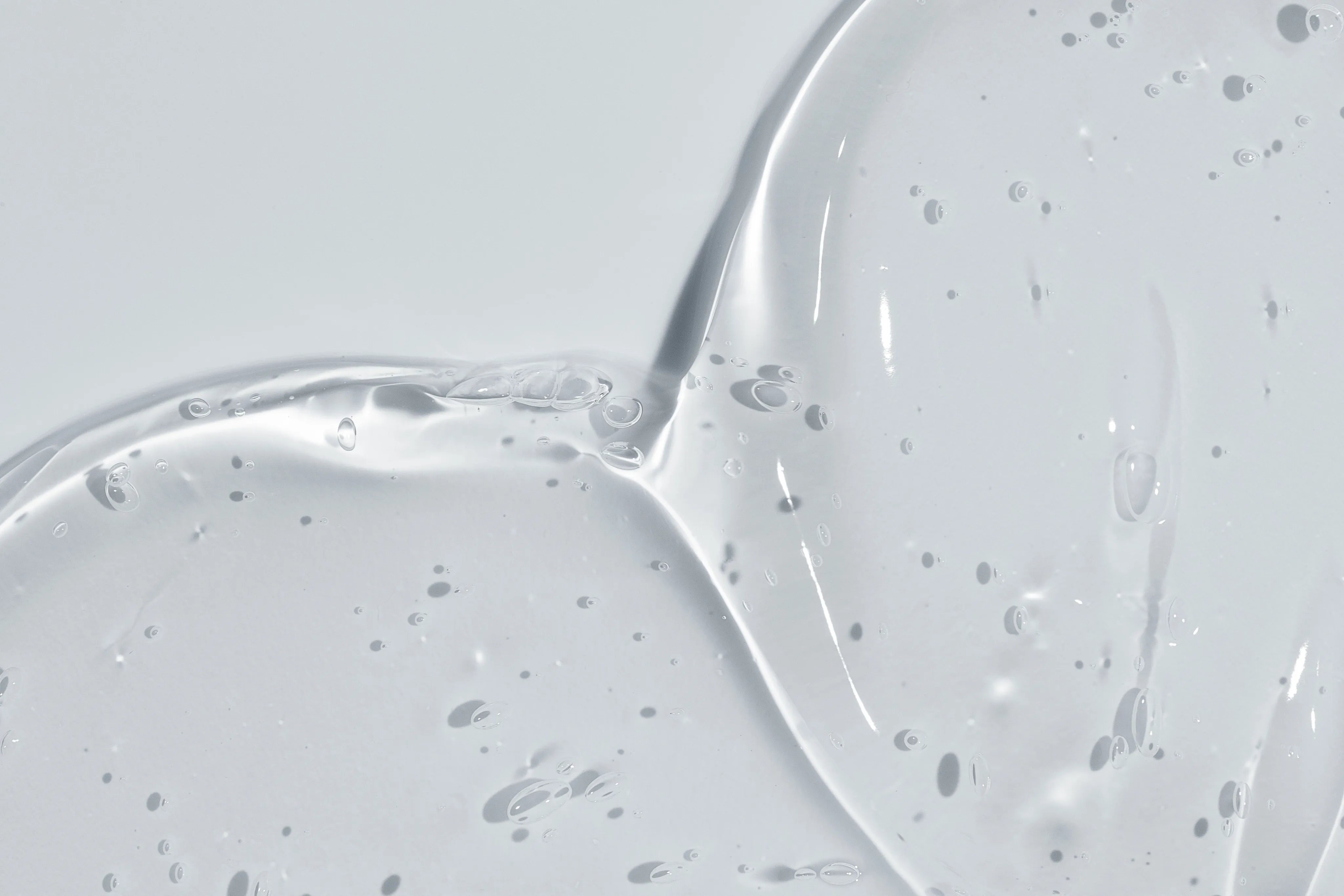 Transparentes flüssiges Gel auf grauem Hintergrund
