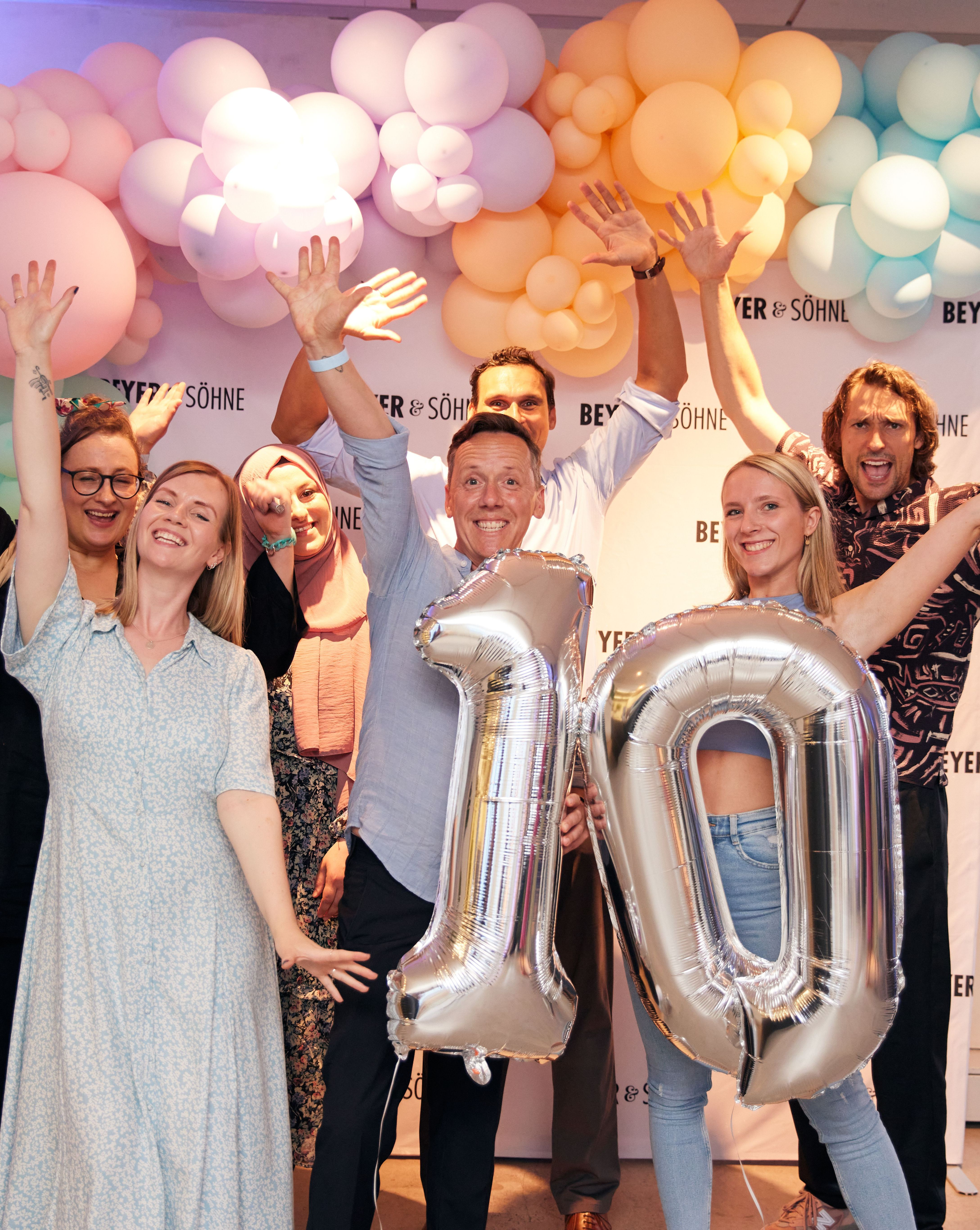 Beyer & Söhne Team mit silbernen Luftballons mit der Zahl 10