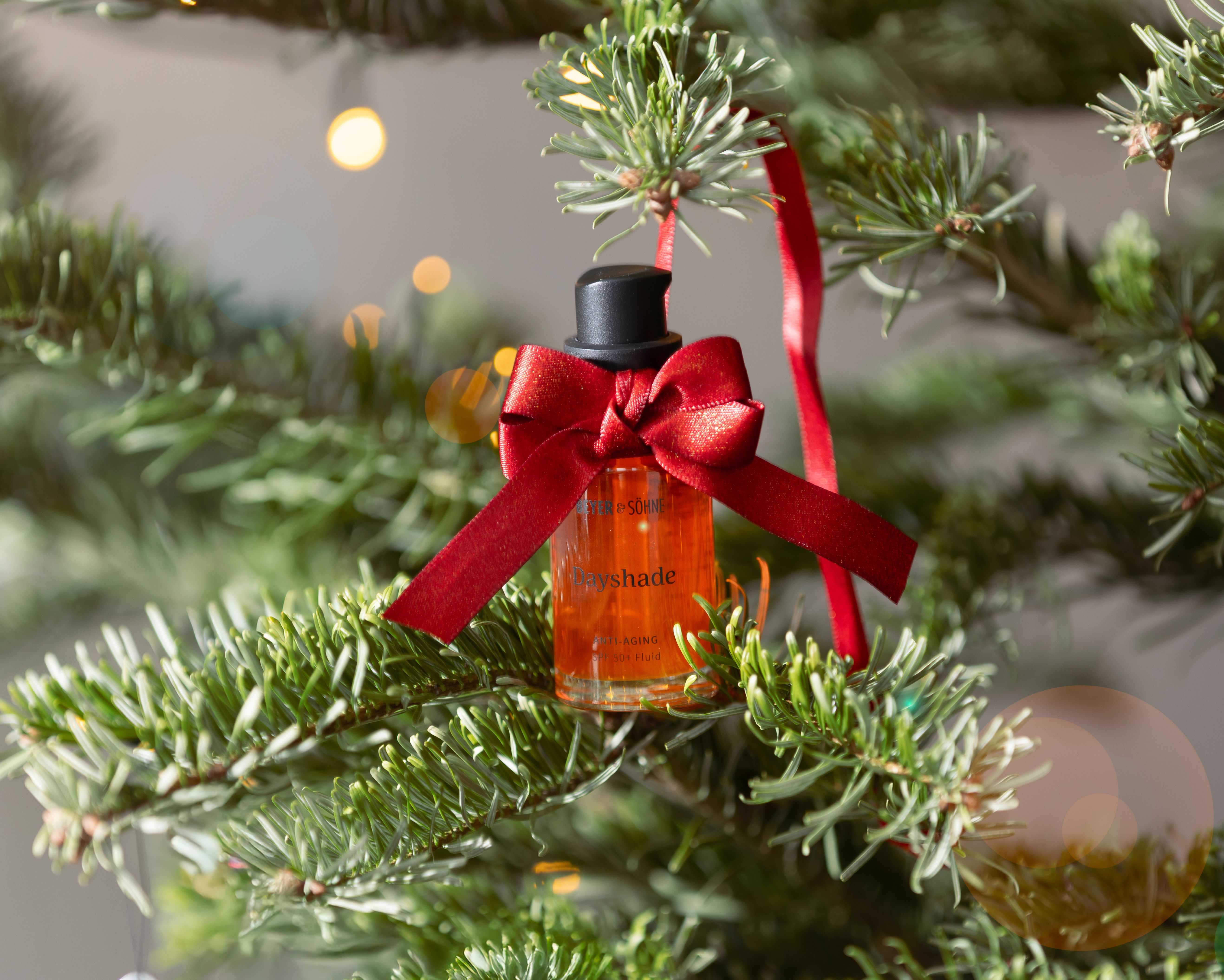 Rotes Dayshade Fluid hängt an einem Tannenbaum mit roter Geschenkschleife