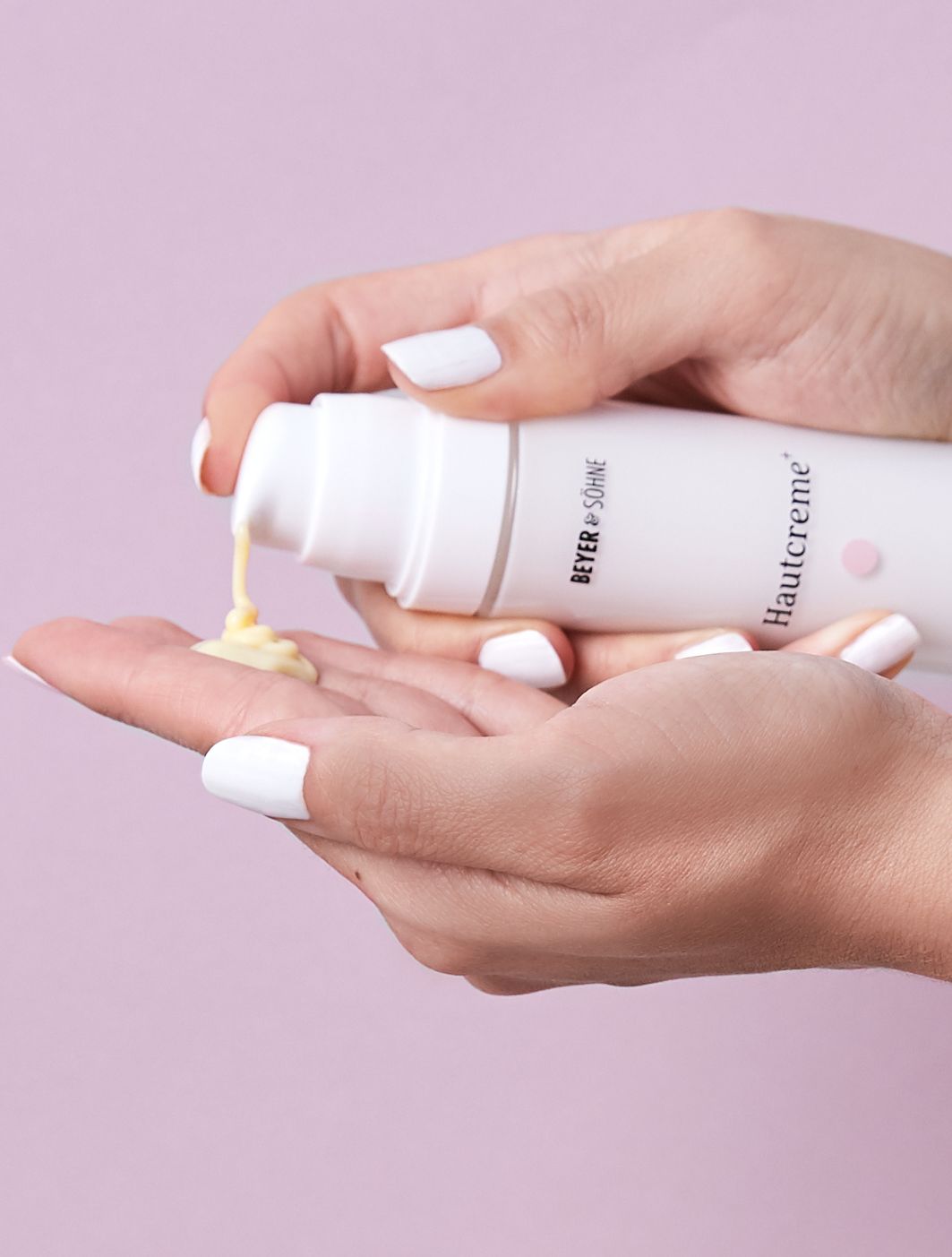 Hände, die eine Creme von Beyer & Söhne mit der Aufschrift Hautcreme+ trockene Haut halten
